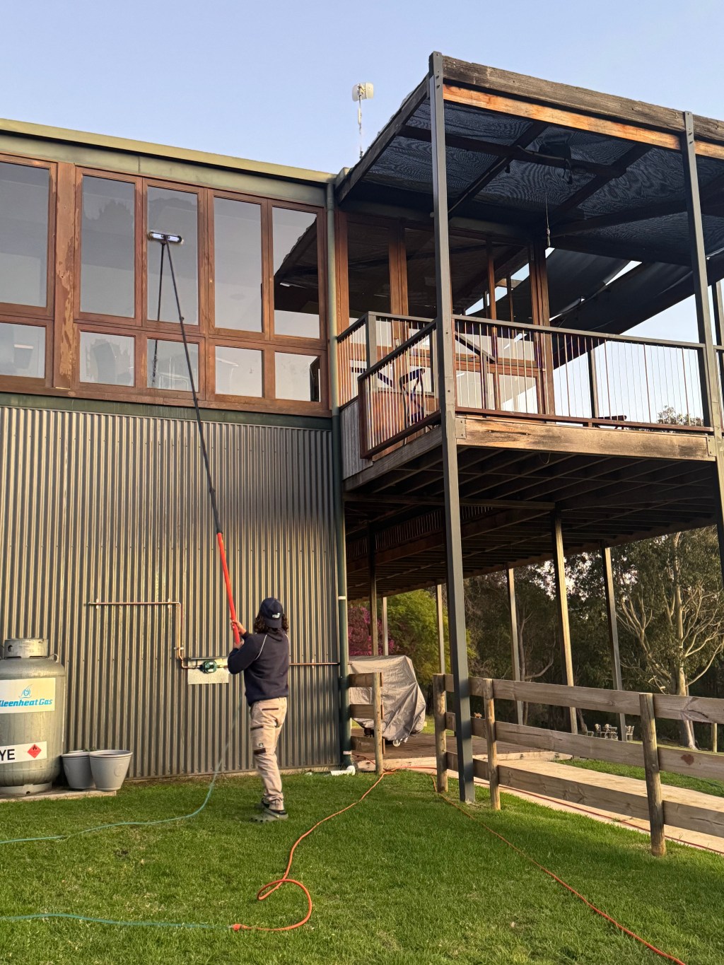 Window cleaner washing tall building with extendable pole